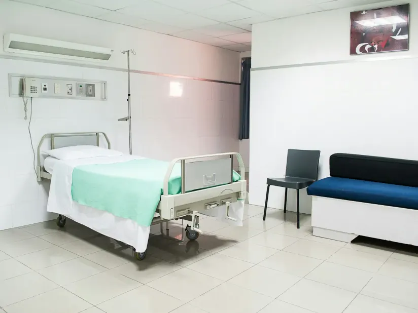 Illustrative treatment room with a bed, chair and infusion stand